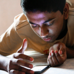 teen looking at his mobile device