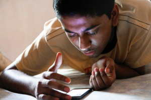 teen looking at his mobile device