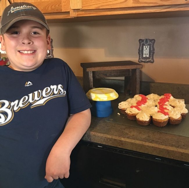 4-H member with blue Brewers shirt displaying his projects.
