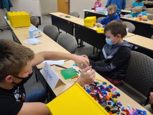 Teen leader helping youth with his Lego project