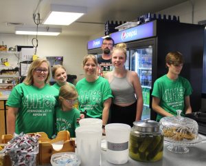 Leaders and members wearing green 4-H shirts are helping at the Teen Leader Association food stand