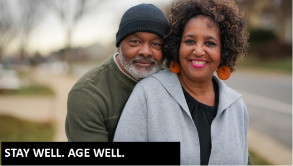 Photo of Black man with a gray beard wearing a sage green shirt with a Black woman wearing a gray cardigan over a black t-shirt